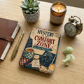 "Mystery is My Comfort Zone" themed item with a notebook, pen, candle, and alarm clock.
