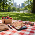 Picnic blanket with berries, journal, pen, sunglasses, and a tablet with inspirational text.