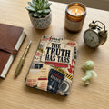 Journal, pen, candle, alarm clock, and a case file design with text "The Truth Has Tabs."